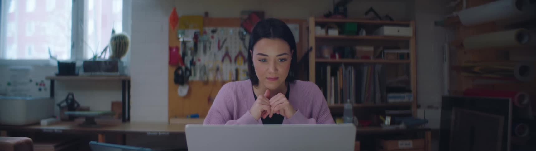 A woman is typing on her laptop in her house