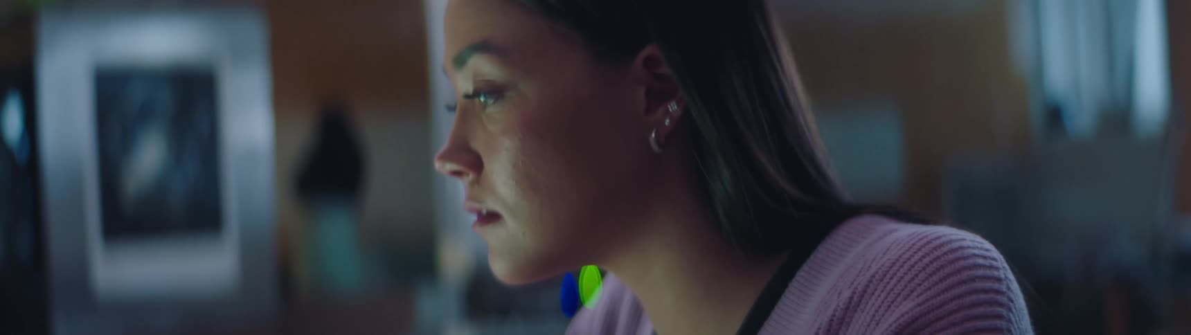 A woman leans forward to have a closer look at the screen