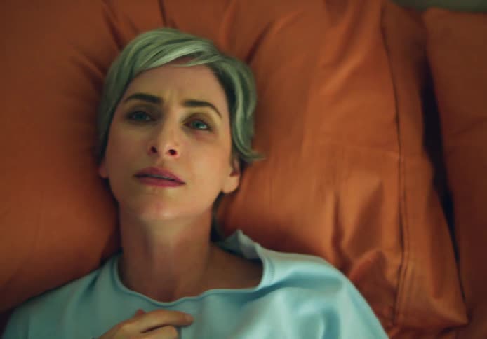 A woman is laying down on her bed
