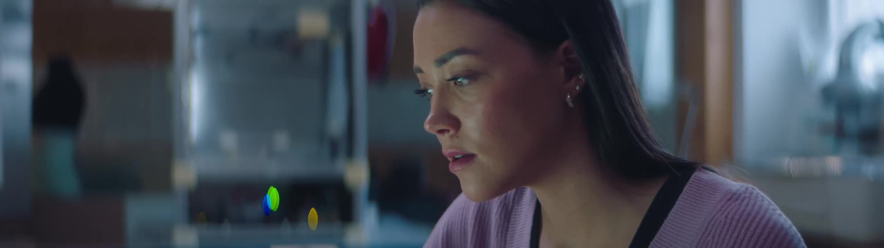 Something on the computer catches a woman's attention and then she sits back in surprise