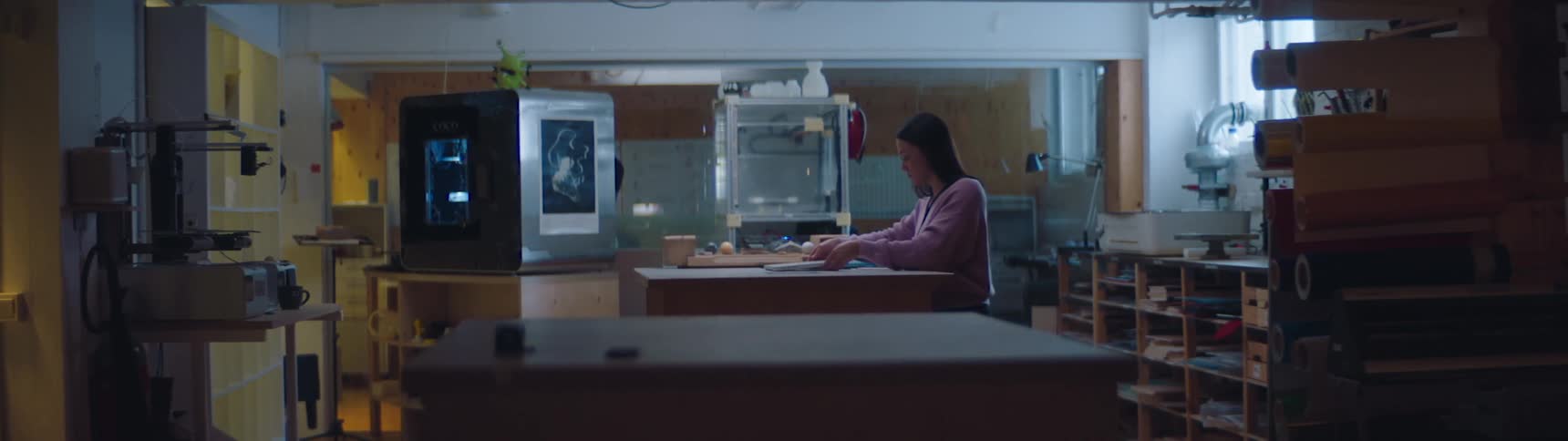 A woman closes her laptop and leaves the office