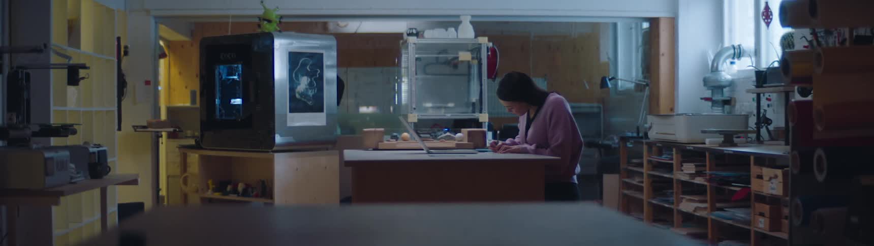A woman is sitting in her kitchen with a laptop