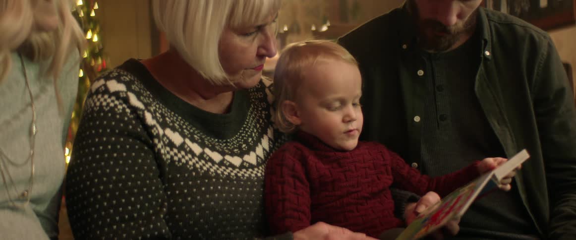 A grandmother reading to her young grandson at christmas time