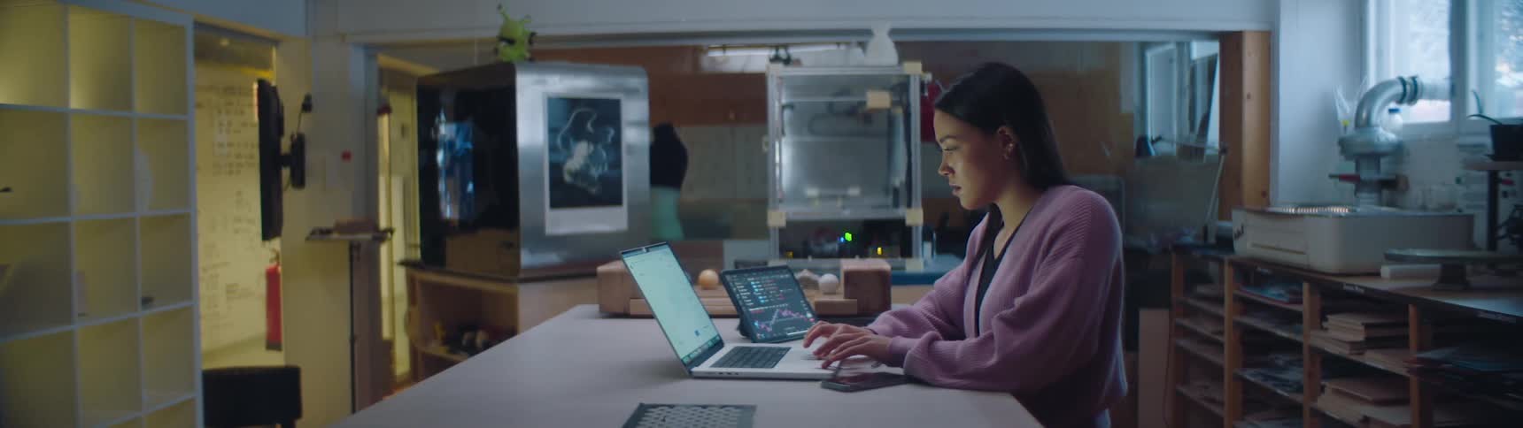 Woman is typing on a laptop at a desk