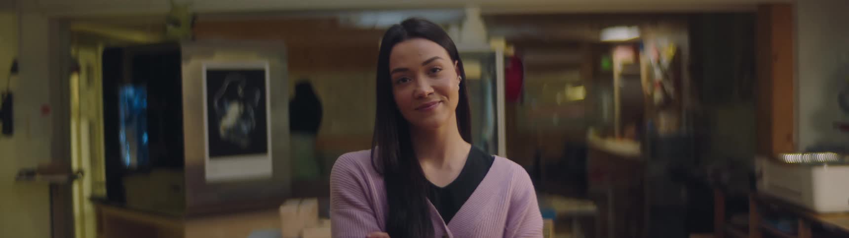 A woman is standing in a room and smiling