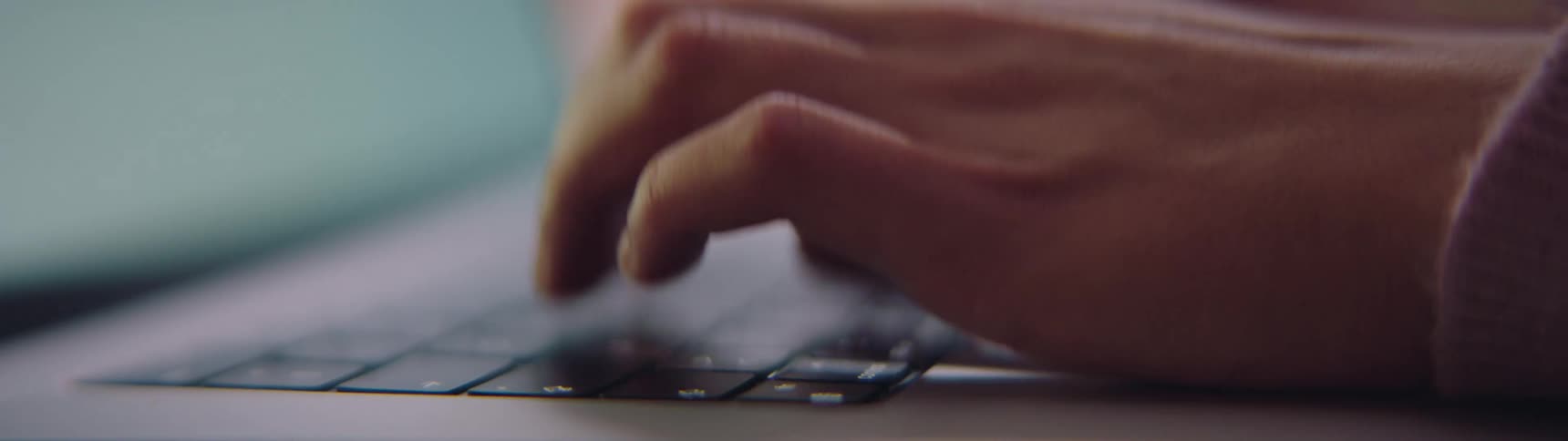 A young woman types on a laptop