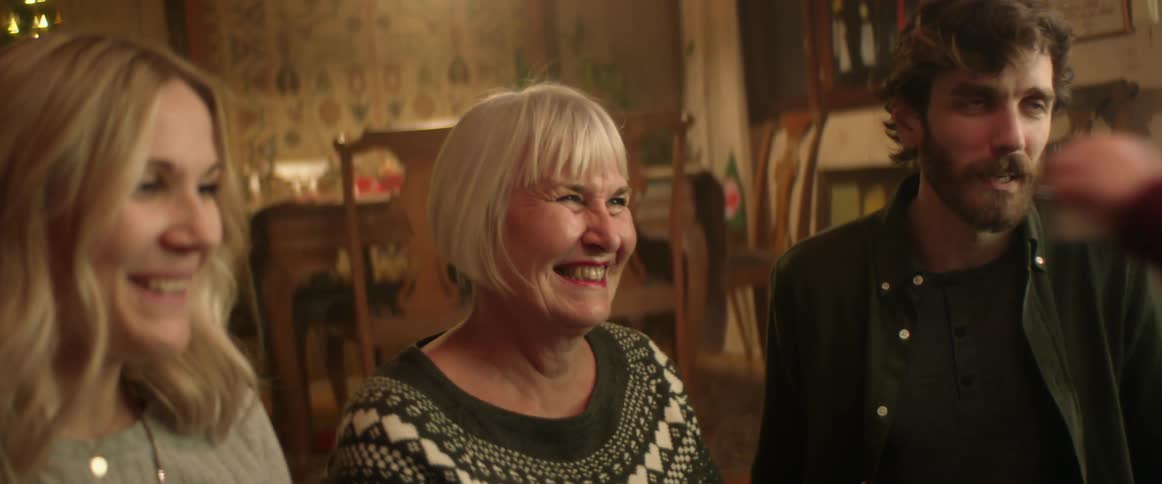 Grandma makes silly faces and dances to make her grandson laugh as mom and dad smile