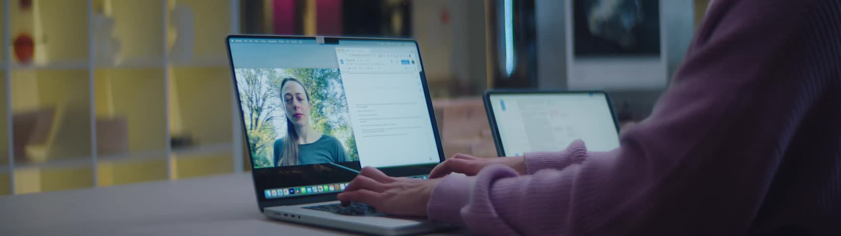 Woman talking on a video call through a laptop over a desk
