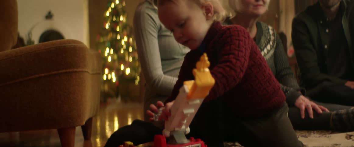 Family watch a child play with a toy truck