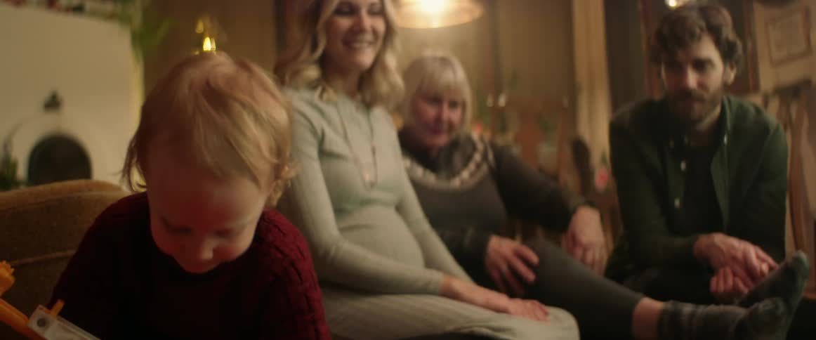 A toddler and family gathered together at christmastime