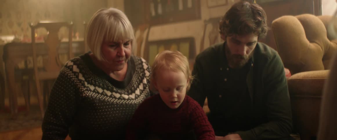 A family watch a boy play with his toy truck