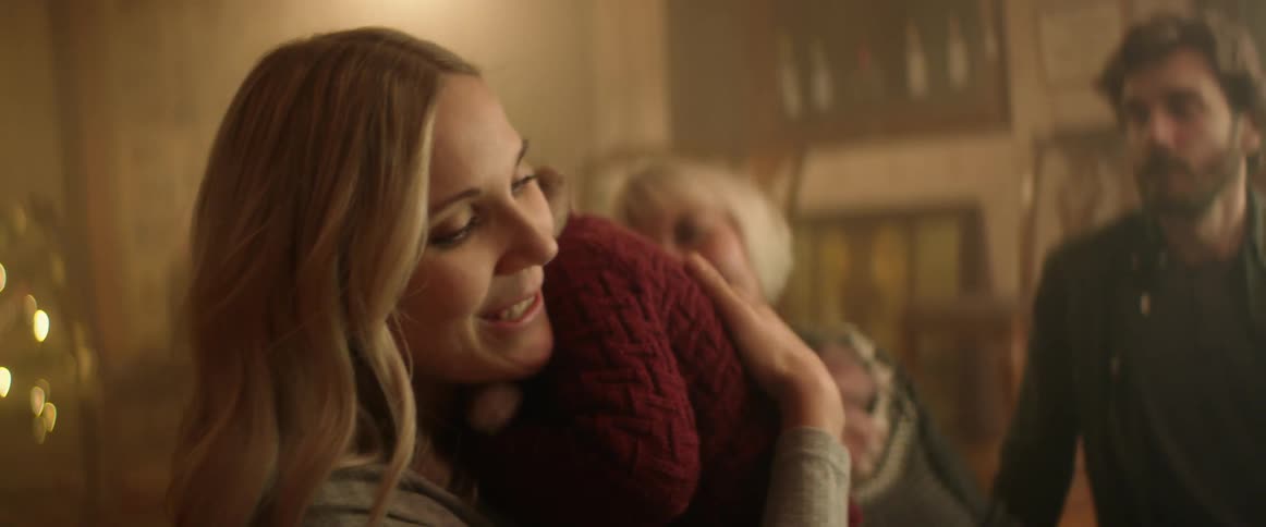 A little boy walks into his mothers arms as dad and grandma look on