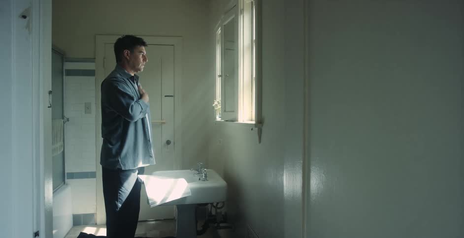 A man is standing in front of a mirror learning sign language