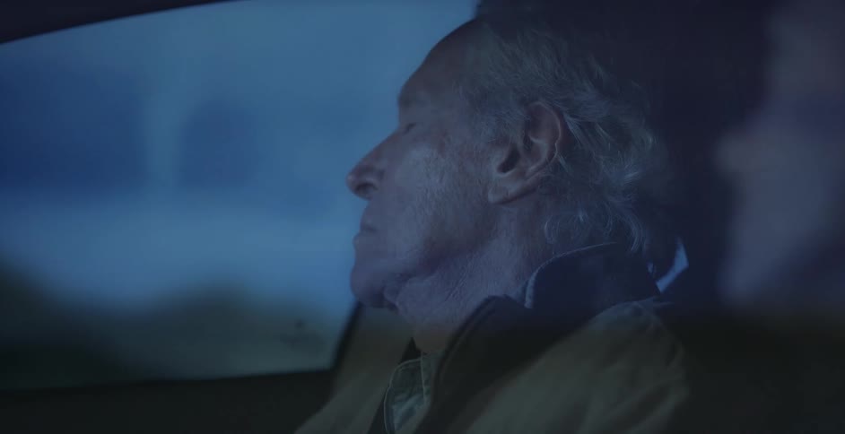 A man is sleeping while being a passenger in a car