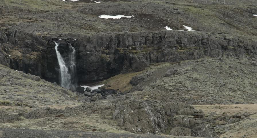 Panning view of an open area which includes a small waterfall