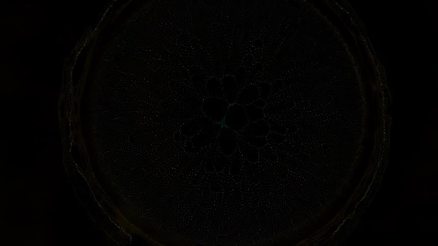 A bright turquoise burst in the darkness with rings around the explosion until it fades away