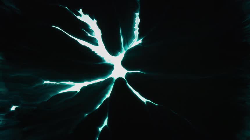 Dark clouds of dye expand from all sides covering the light