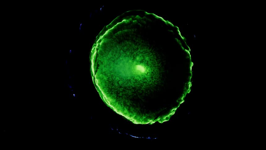 A green ring of light grows in the darkness and lights up like a green portal