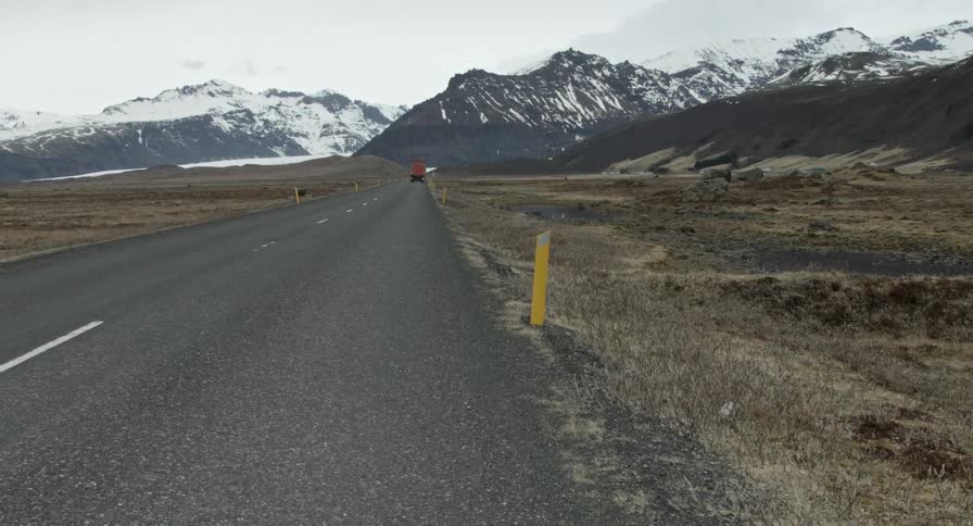 Red truck traveling along a mountain highway