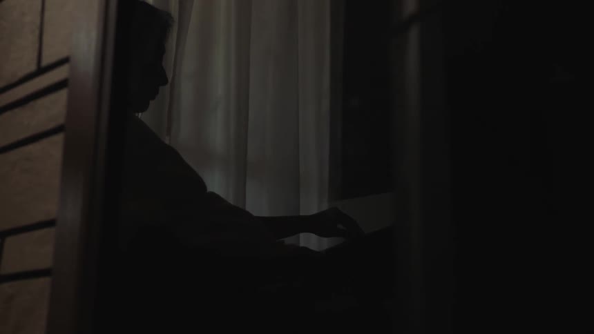 A silhouette reflection of a pregnant woman reading