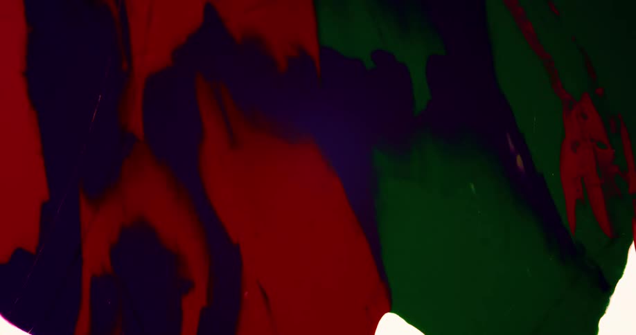 Paint in various colors spreads to cover pale surface