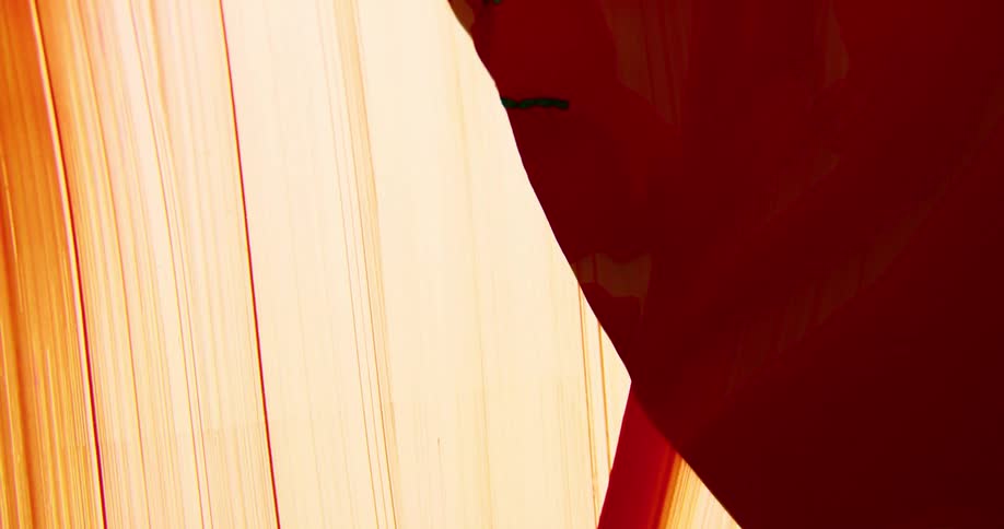 Crimson spreads down translucent surface as symbols are drawn on surface not yet coated
