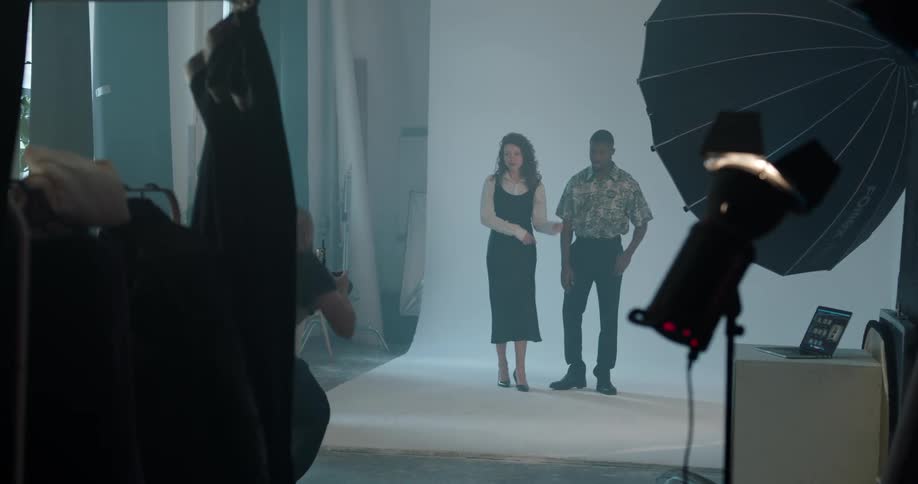 Woman fixing the clothes on models posing for the camera on a photo shoot