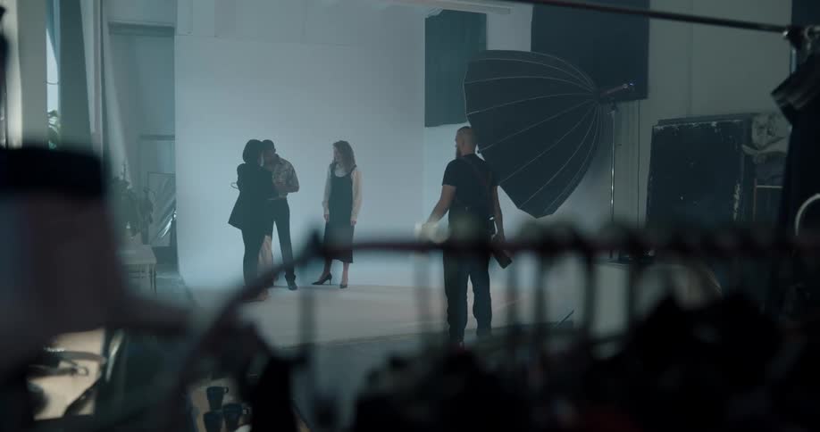 A stylist brings a new shirt to a model during a photo shoot