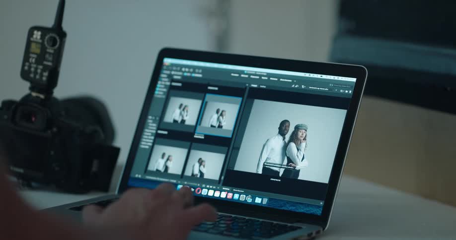 Someone is looking through photographs on a laptop computer and a camera is on the table