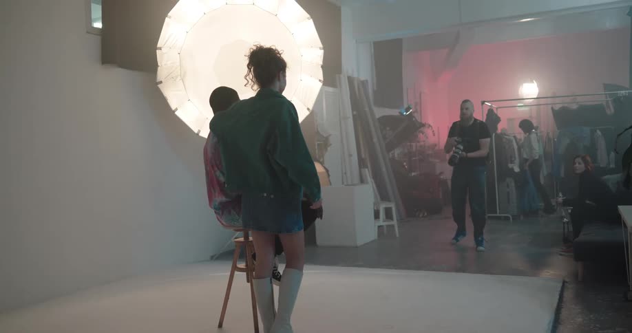 A photographer takes photos of models in a studio