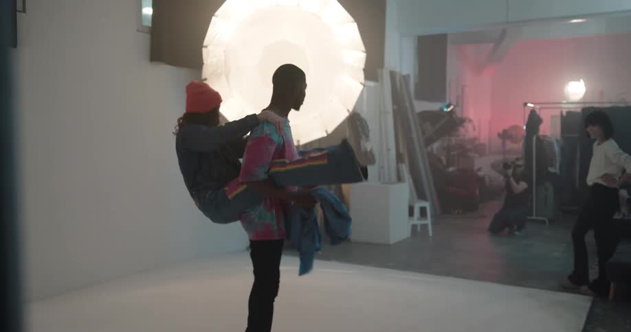 Photographer takes pictures as fashion models move through poses