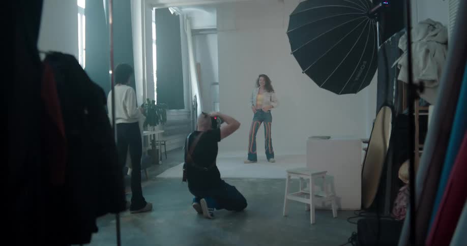 Photographer takes pictures of fashion model in photography studio
