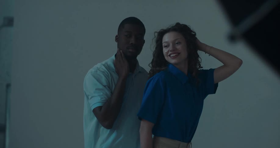 Male and female fashion models move through poses at fashion shoot