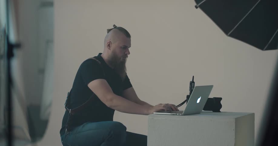 A photographer plugs a photo card into his laptop during a photo shoot