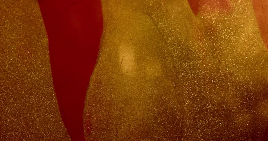 Gold glitter surface contrasts with smooth crimson