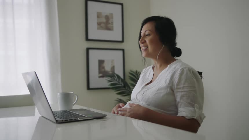 A woman is talking on her laptop