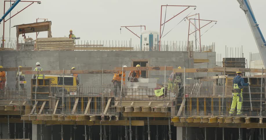 Group of workers wearing hardhats and protective equipment working at a construction site