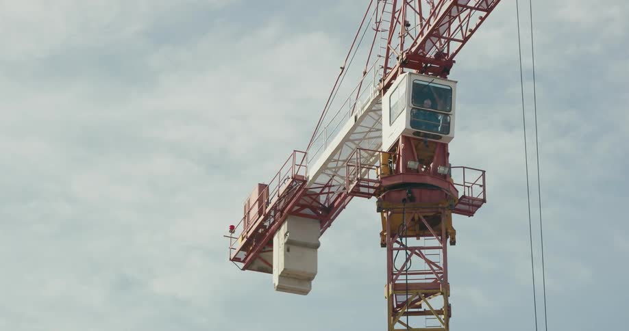 A construction employee is operating a crane