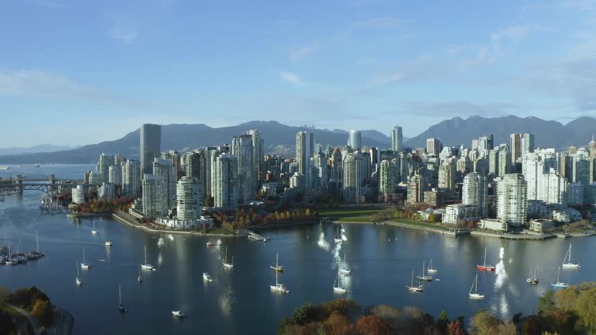 Aerial view of boats floating on a river in front of the the skyscrapers on Vancouver