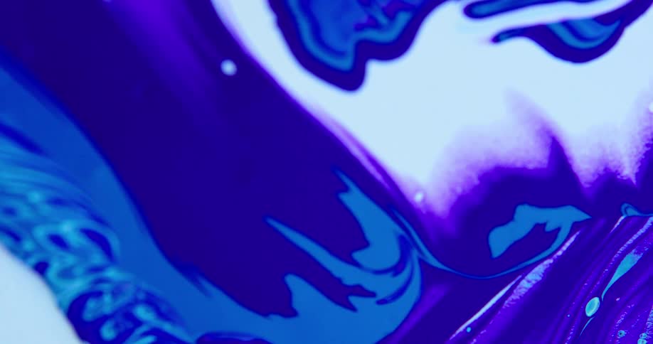 Camera spins over a surface covered with streaks and blobs of psychedelic white and blue liquid ink