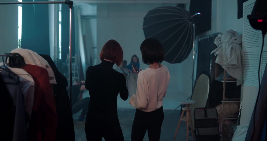 Photographers take pictures in a studio and talk