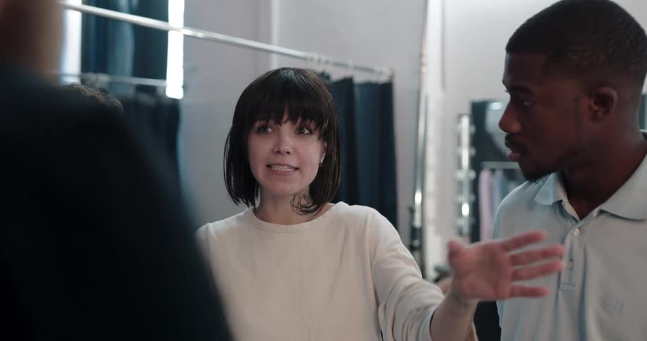 Girl on a group of models explaining while gesturing during a break in the photoshoot