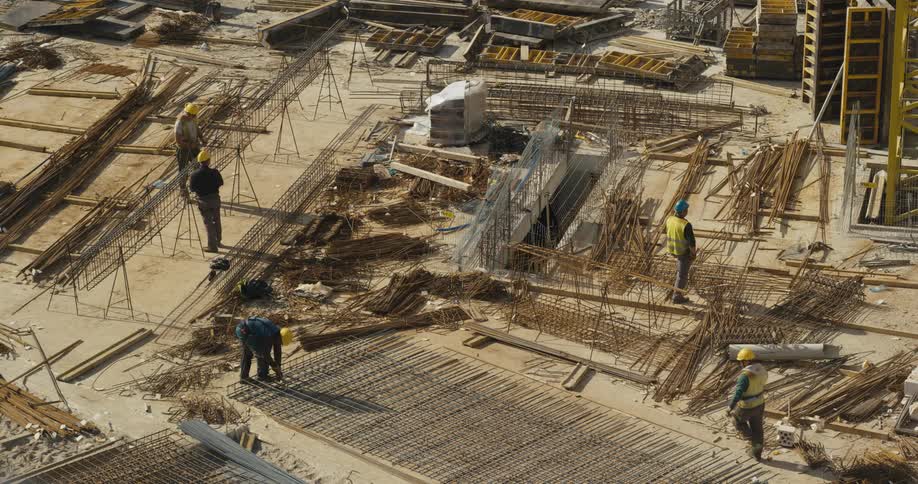 Group of workers wearing hardhats and protective equipment working at a construction site