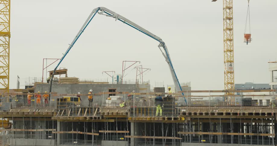 Construction employees are working on a building outdoors at dusk
