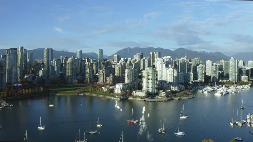 Boats sail in the ocean near downtown Vancouver
