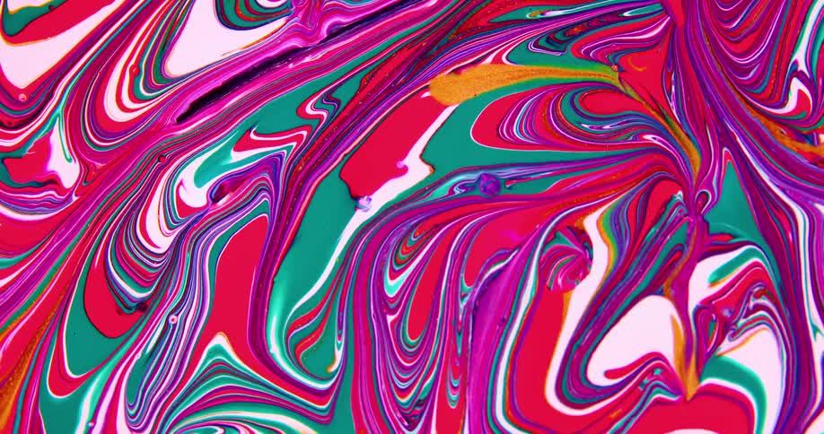 Camera spins over a surface covered with streaks and blobs of psychedelic liquid ink