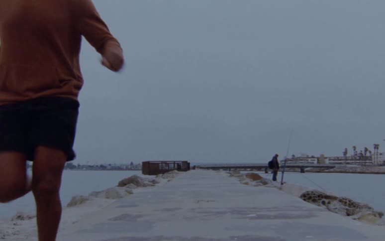 A group of men are jogging outdoors at dusk