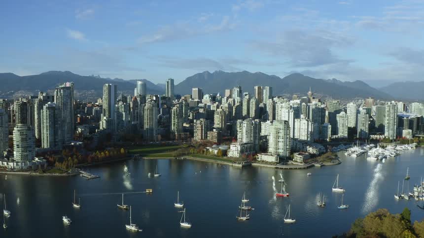 An aerial view of boats on the water in front of Vancouver skyline