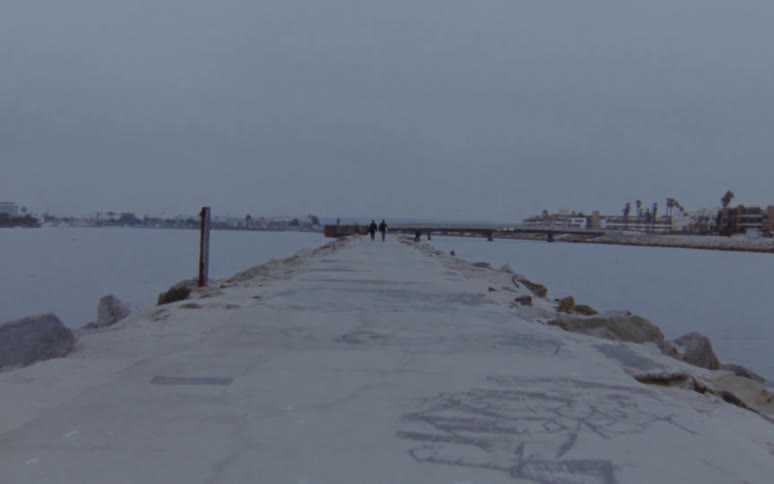 A group of men are jogging by the ocean