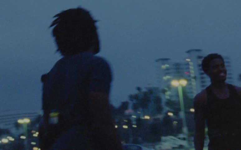 A group of friends are outdoors at night in a city